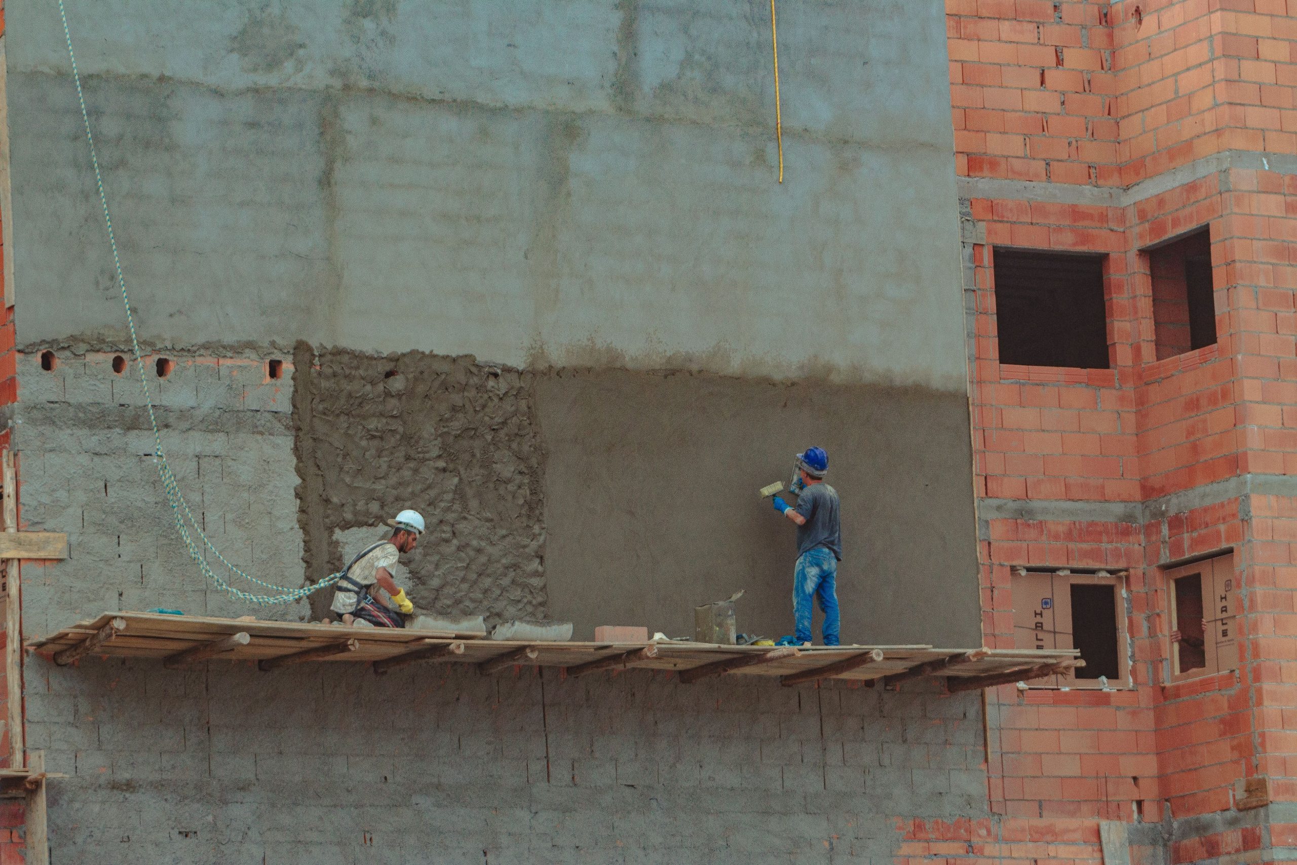 Construction façade avec ouvriers en équipement sécurité