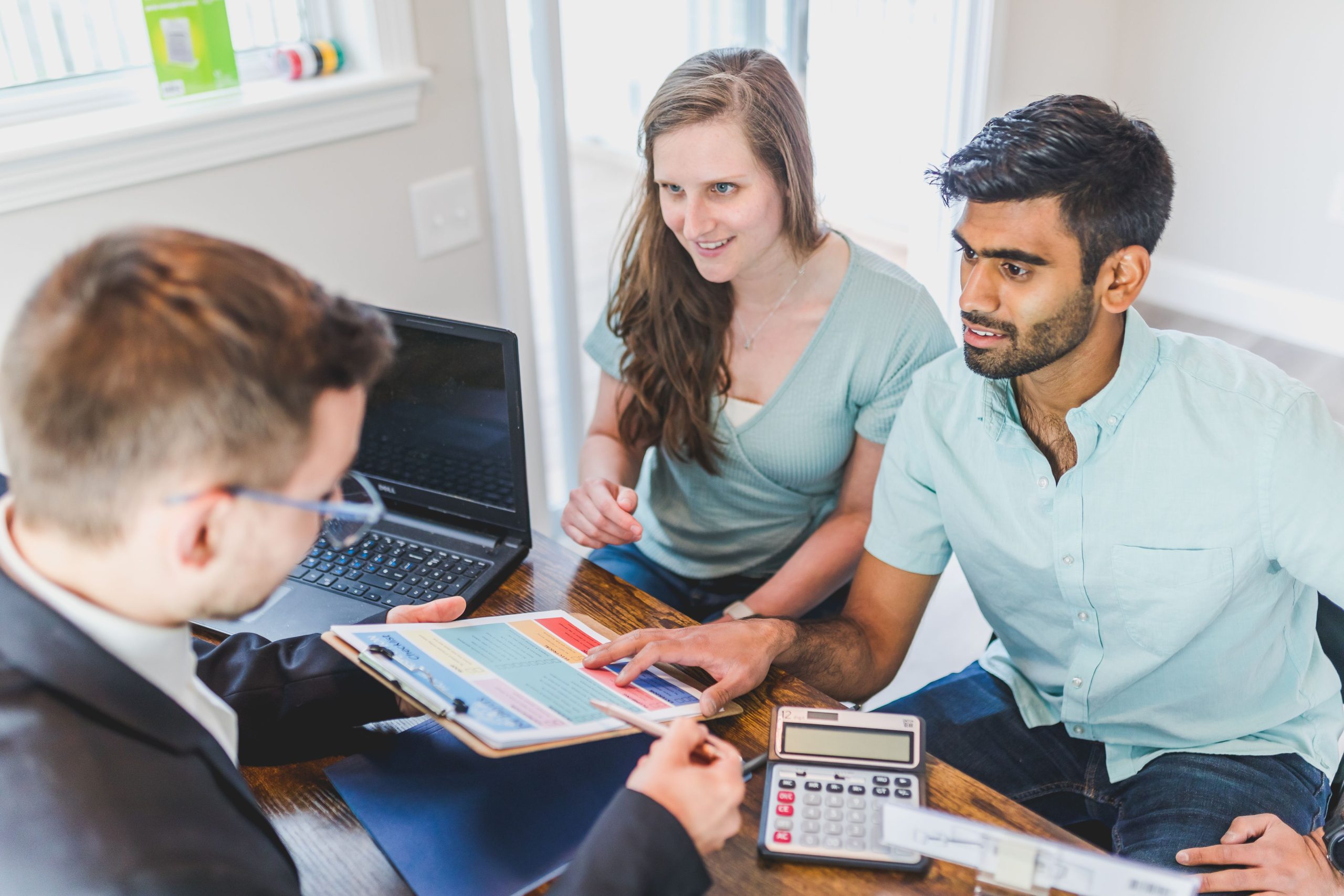 Couple consultation agent immobilier achat maison calculatrice