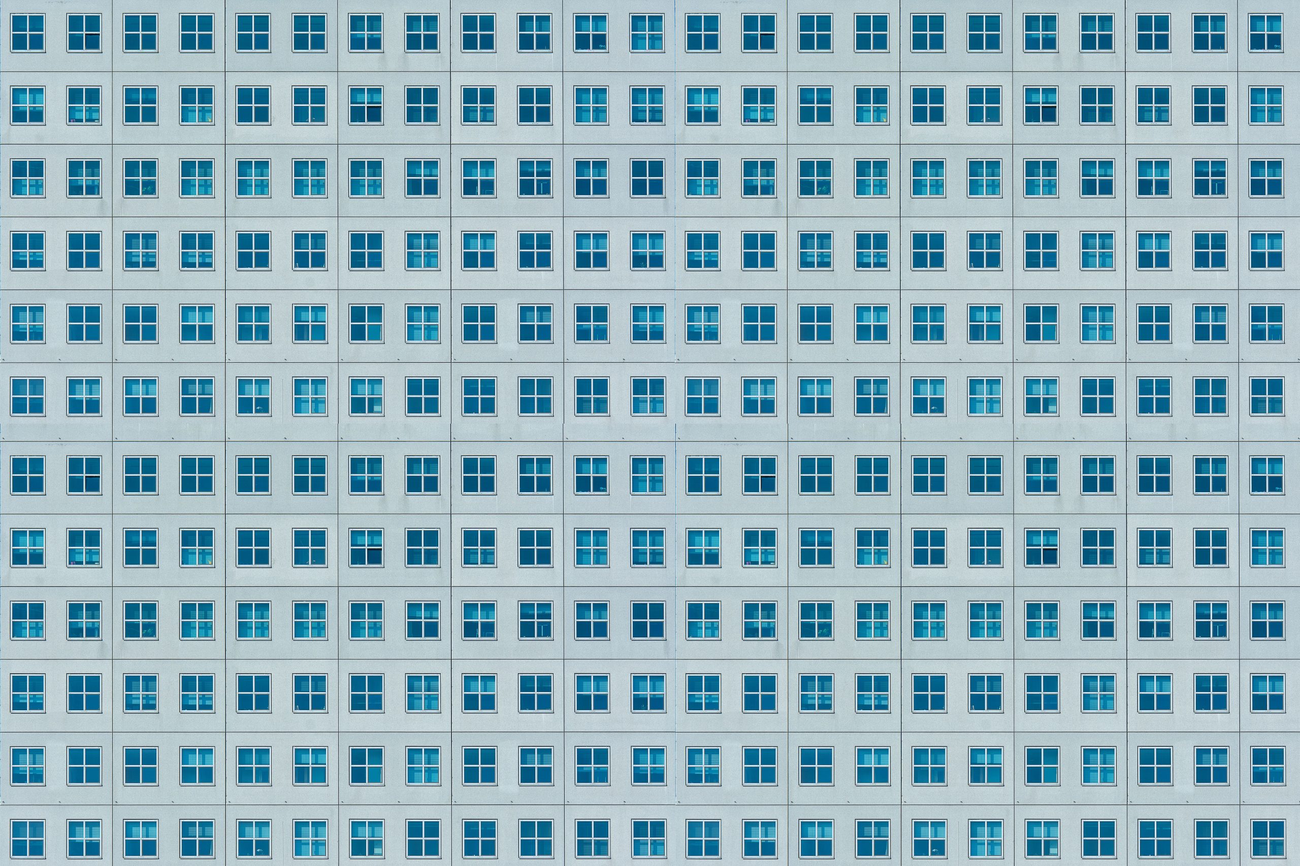 Façade d'immeuble aux fenêtres symétriques et répétitives