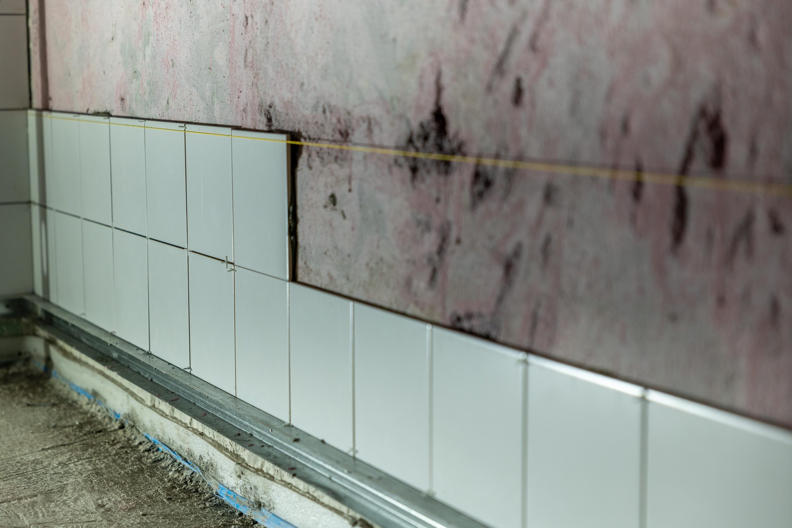 Gros plan sur un mur partiellement carrelé en rénovation