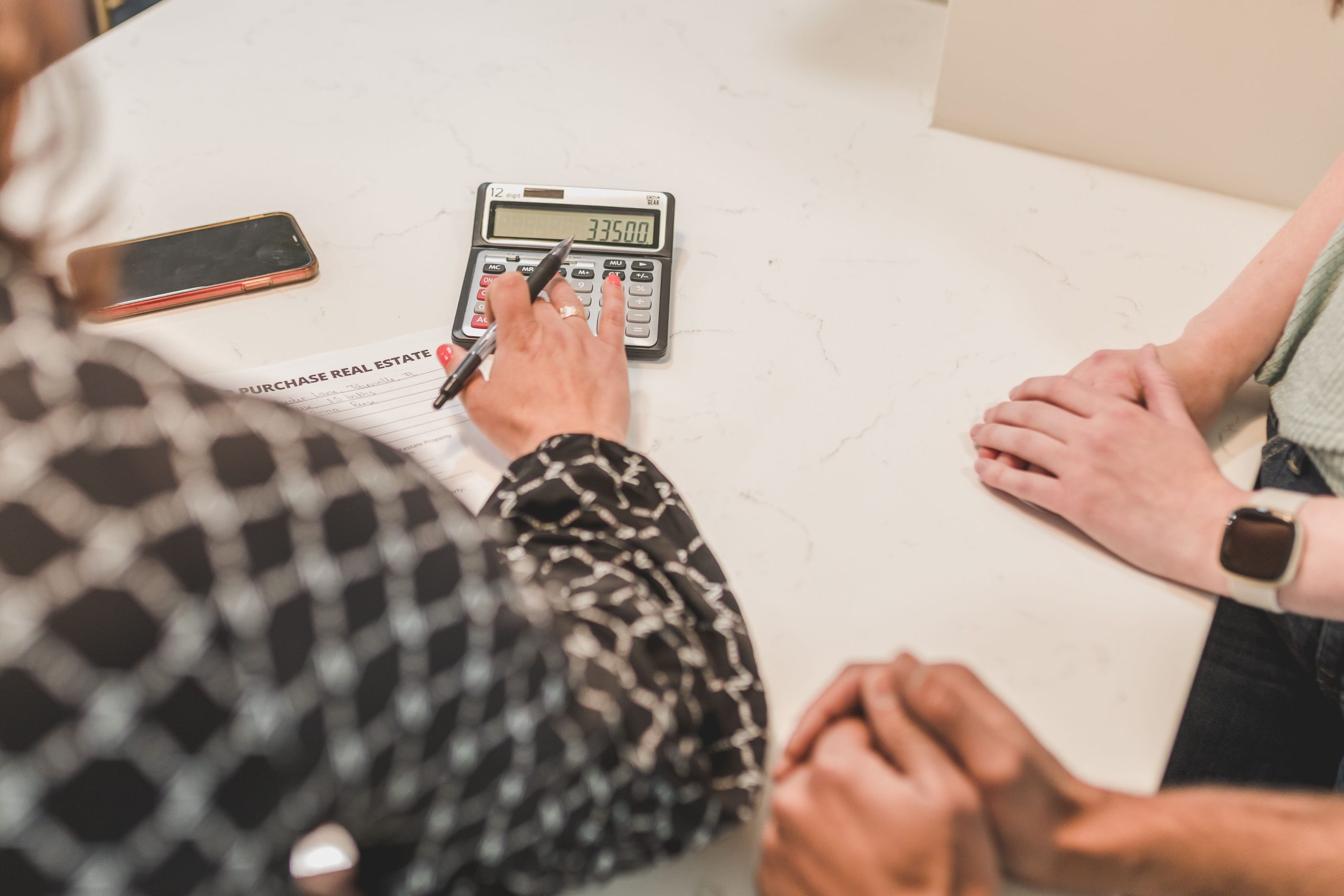 Mains signant document achat immobilier avec calculatrice